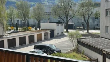 Balkon mit Holzzaun und einem Schmetterlingsstuhl, der einen weiten Blick auf die Berge bietet.
