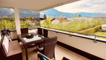 Geräumige Terrasse mit Sitzgelegenheiten und einem weiten Blick auf die umliegende Berglandschaft.