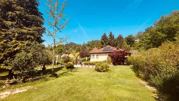 Weitläufiger Garten mit gepflegtem Rasen und Blick auf das charmante Einfamilienhaus.