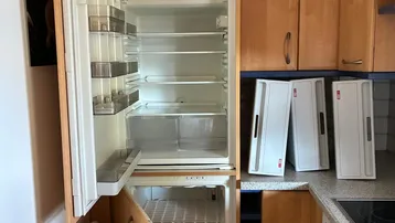 Küche mit Holzschränken, integriertem Kühlschrank und Kochfeld.