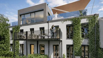 Moderne Wohnanlage mit begrünten Fassaden, Balkonen und einer großzügigen Dachterrasse unter blauem Himmel.