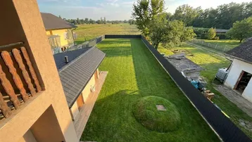 Weitläufiger Gartenbereich mit gepflegtem Rasen und Blick auf die umliegende Landschaft und Felder.