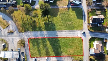 Luftaufnahme eines Grundstücks mit roter Umrandung, umgeben von Straßen und Wohngebäuden.