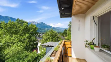 Kleiner Balkon mit Holzboden und atemberaubendem Blick auf die umliegenden Berge und das Tal.