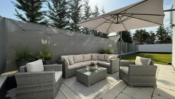Gemütliche Terrasse mit modernen Gartenmöbeln und Sonnenschirm, ideal für entspannte Stunden im Freien.
