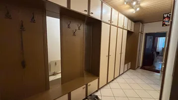 Geräumiger Flur mit Einbauschränken, Garderobe und Fliesenboden, der viel Stauraum bietet.