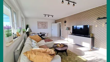 Helles Wohn- und Esszimmer mit modernem Design, Parkettboden und dekorativer Tapete.