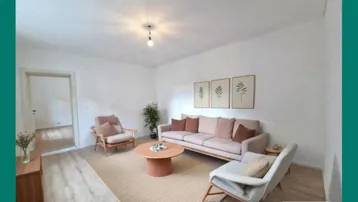 Helles, virtuell inszeniertes Wohnzimmer mit modernem Sofa, Sesseln und hellem Holzboden.