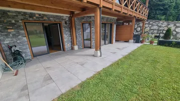 Große gepflasterte Terrasse mit direktem Zugang zum Garten und Blick auf die Natur.
