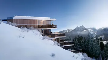 Moderne Architektur in den Bergen mit großen Glasfronten und Terrassen, umgeben von Schnee.