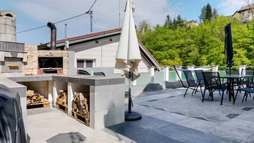 Geräumige Dachterrasse mit Außenküche, Grillbereich und Essplatz, ideal für gesellige Abende.