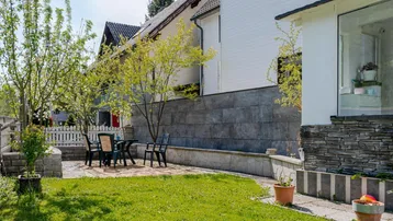 Gemütliche Terrasse mit Rasenfläche und Gartenmöbeln, ideal für entspannte Stunden im Freien.
