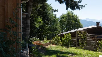 Gartenbereich mit Hochbeeten und weitem Blick auf die umliegende Berglandschaft.