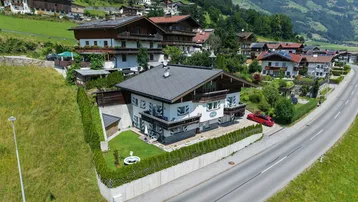 Luftaufnahme des Hauses mit Garten und umliegender Berglandschaft in ländlicher Umgebung.