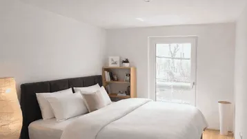 Helles Schlafzimmer mit Holzboden, großem Bett und Zugang zum Außenbereich.