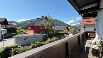 Geräumiger Balkon mit Sitzgelegenheiten und weitem Blick auf die umliegende Berglandschaft.
