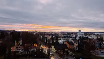 Panoramablick über die Stadt bei Sonnenuntergang mit Wohngebäuden und Straßen.