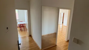 Heller Flur mit Parkettboden und einem gro ßen Spiegelschrank, der den Raum optisch erweitert.