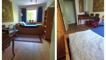 Helles Schlafzimmer mit Holzbett, Parkettboden, blauen Vorhängen und einem schönen Blick ins Grüne.