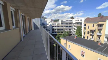 Weitläufiger Balkon mit Panoramablick auf die Stadt und die umliegende Bebauung.