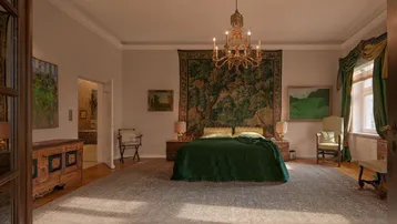 Elegantes Schlafzimmer mit großem Wandteppich, Kronleuchter und traditionellen Möbeln.
