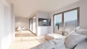 Heller, offener Wohn- und Essbereich mit Holzboden, großen Fenstern und Bergblick.