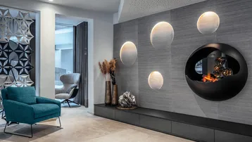Stilvolle Lounge mit modernem Kamin, dekorativen Wandleuchten und bequemen Sitzgelegenheiten.