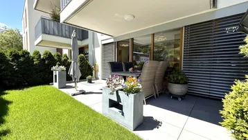 Geräumige Terrasse mit Gartenmöbeln und direktem Zugang zum gepflegten Rasenbereich.