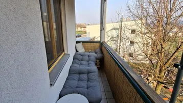 Gemütlicher Balkon mit Sitzgelegenheiten, Fliesenboden und einem weiten Blick auf die Umgebung.