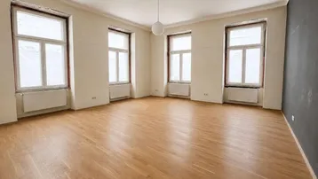 Helles, renoviertes Zimmer mit neuem Parkettboden und hohen Fenstern, bereit zur Einrichtung.