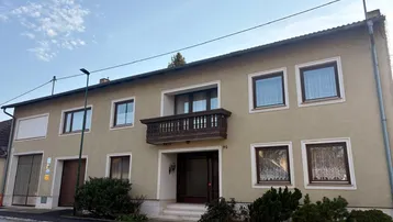 Ansicht des Wohnhauses von der Straße mit Balkon und traditioneller Fassade.