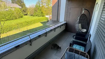 Möblierter Balkon mit Sitzgelegenheiten und weitem Blick ins Grüne.