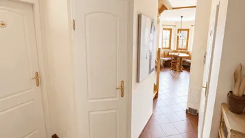 Heller Flur mit Terrakottafliesen und Blick in den offenen Wohnbereich.