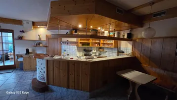 Gemütlicher Innenbereich mit Holzvertäfelung, Bar und Sitzgelegenheiten, ideal für gesellige Runden.