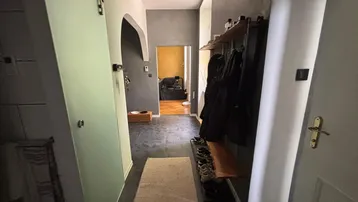 Moderner Flur mit Garderobe, dunklem Boden und Blick in angrenzende Räume.