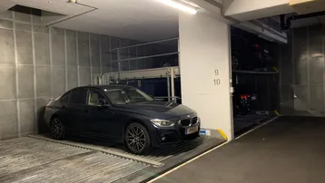 Tiefgarage mit automatischem Parksystem und einem geparkten Fahrzeug auf einer Plattform.