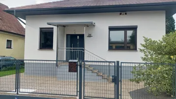 Vorderansicht des Hauses mit modernem Eingangsbereich und Vorgarten.
