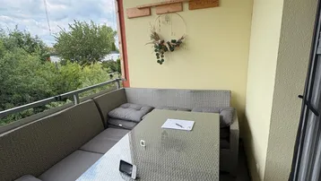 Gemütlicher Balkon mit Sitzgruppe und Blick ins Grüne.