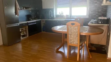 Geräumige Küche mit Essbereich, Fenster und Blick ins Grüne, ausgestattet mit einem Kühlschrank.