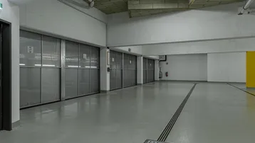 Geräumige Tiefgarage mit individuellen Abstellboxen und sauberem Betonboden, gut beleuchtet.