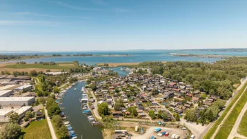 Luftaufnahme einer Siedlung am Wasser mit vielen kleinen Häusern und Bootsanlegestellen.