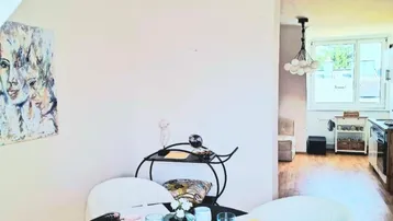 Heller Essbereich mit modernem runden Tisch und Blick in die angrenzende Küche.