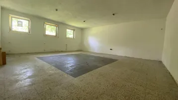 Geräumiger Lagerraum mit hellen Wänden und robustem Fliesenboden, ideal für verschiedene Zwecke.