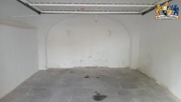 Geräumige Garage mit gewölbter Rückwand und robustem Steinboden, ideal für ein Fahrzeug oder Lagerung.