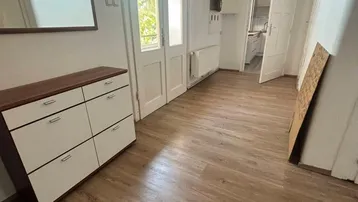 Helle Diele mit Laminatboden, Schuhschrank und Zugang zu weiteren Räumen.