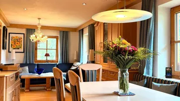 Helles Wohn- und Esszimmer im alpinen Stil mit Holztäfelung und gemütlicher Atmosphäre.