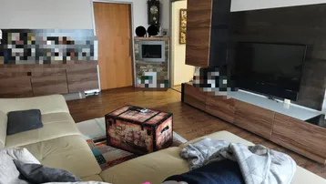 Geräumiges Wohnzimmer mit großem Sofa, moderner Medienwand und einem dekorativen Kamin, der Wärme spendet.