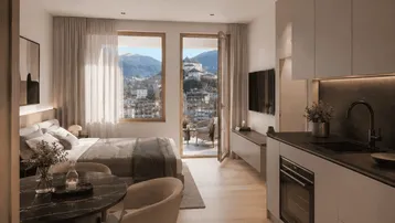Helles Studio-Apartment mit moderner Küchenzeile, Schlafbereich und Balkon mit beeindruckendem Bergblick.