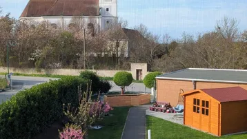Blick auf die Umgebung mit einer Kirche im Hintergrund und einem gepflegten Gartenweg.