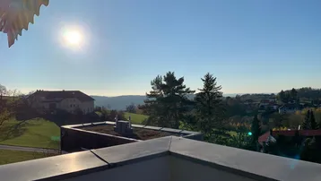 Panoramablick vom Balkon über die hügelige Landschaft und umliegende Bebauung.